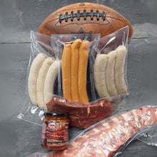 Super-Bowl-Box mit Würstchen, Grillsauce und Spareribs neben einem Football