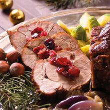 Weihnachtlicher Rollbraten mit Cranberrysauce und Rosenkohl auf festlicher Tafel