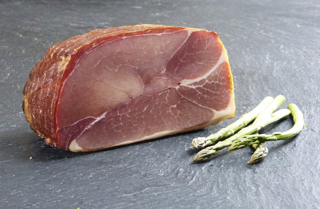 Rohschneider angerichtet mit grünem Spargel auf Schieferhintergrund