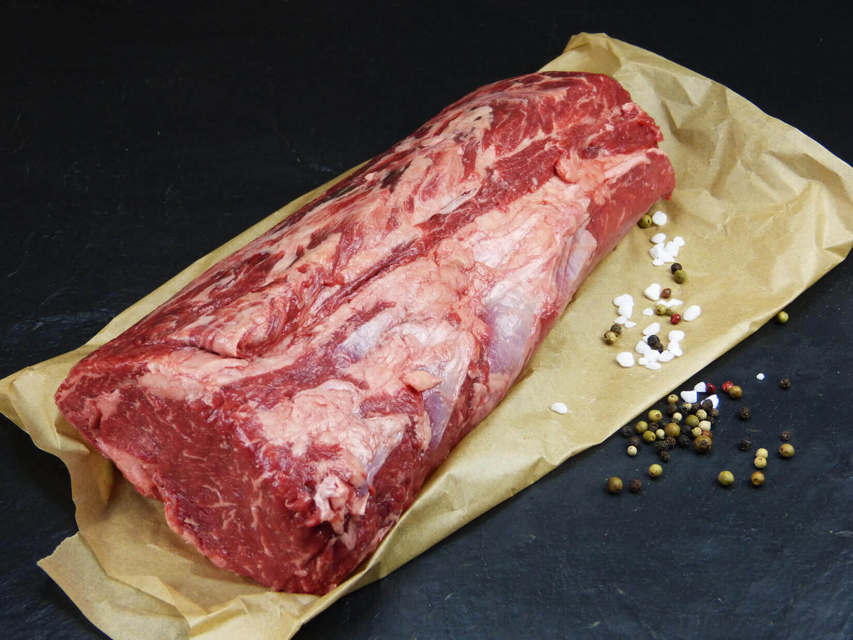 Argentinische Entrecôte am Stück angerichtet mit einer Gewürzmischung auf Backpapier mit Schieferhintergrund