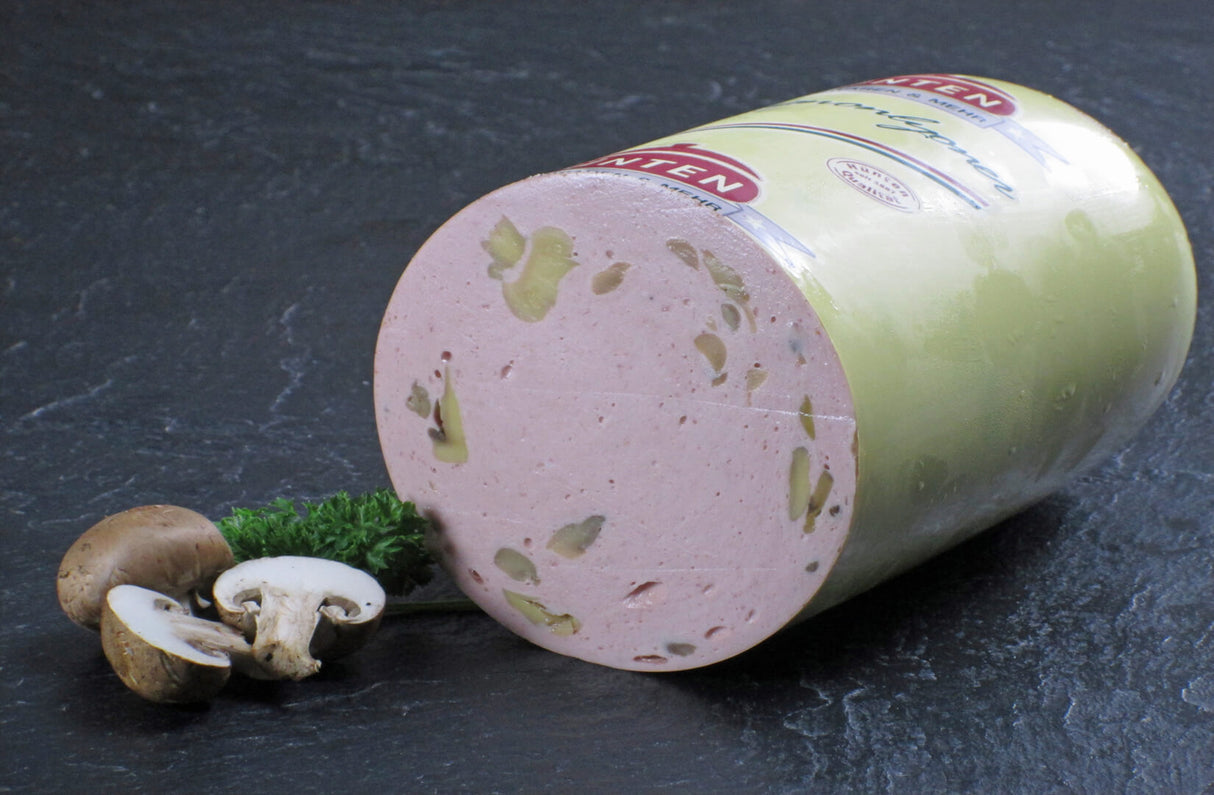 Eine halbe Champignon Lyonerwurst vom EIFEL Schwein angerichtet mit Champignon Pilzen und Petersilie auf Schieferhintergrund