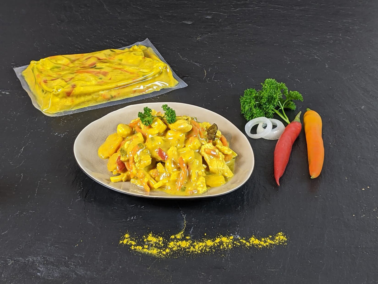 Puten Curry im Kochbeutel und gegart Kochbeutel mit Paprika auf Schhieferhintergrund