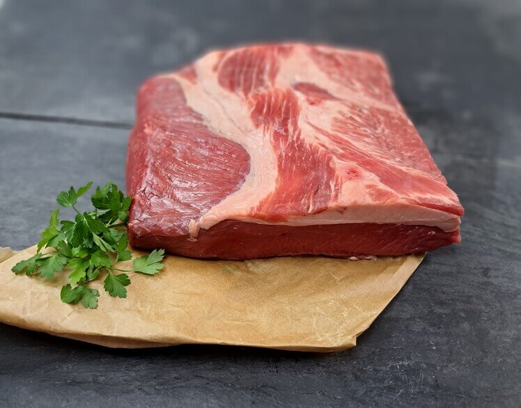 Jungbullen Brust mit glatter Petersilie auf Schieferhintergrund