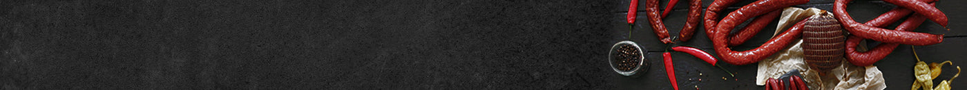 Banner Nussschinken mit Luftgetrocknetet Mettwurst und Chilie und Pfeffer auf Schieferhintergrund