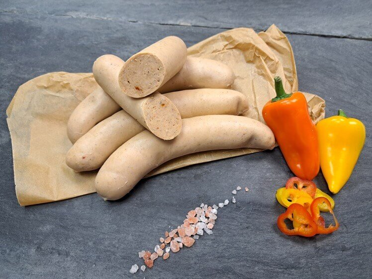 Rostbratwurst Tex Mex roh mit Parika auf Schieferhintergund