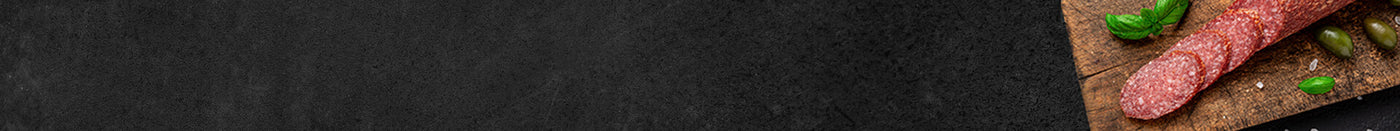 Banner Salamistange im Anschnitt mit Basilikum auf Schieferhintergrund