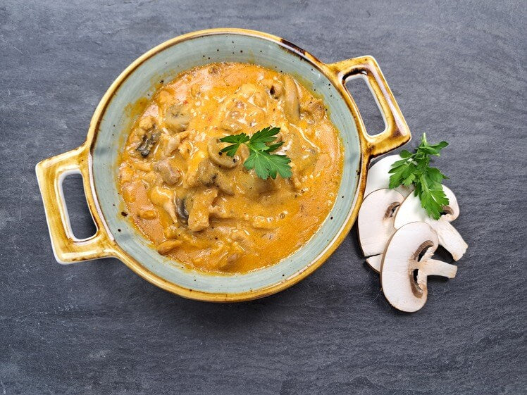 Schweine Geschnetzeltes Braumeister Art im Topf mit Champignons auf Schieferhintergrund