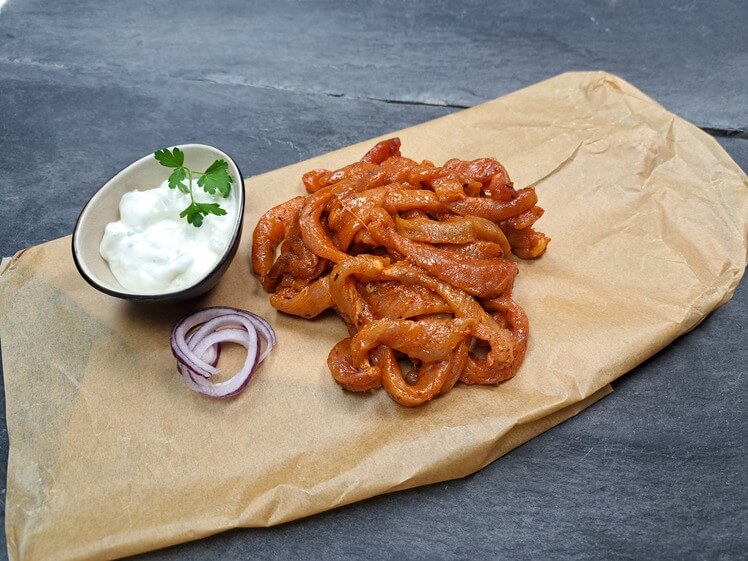 Schweine Streifenfleisch Gyros Art mit Tzatziki und rote Zwiebeln auf Schieferhintergrund