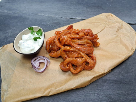Schweine Streifenfleisch Gyros Art mit Tzatziki und rote Zwiebeln auf Schieferhintergrund