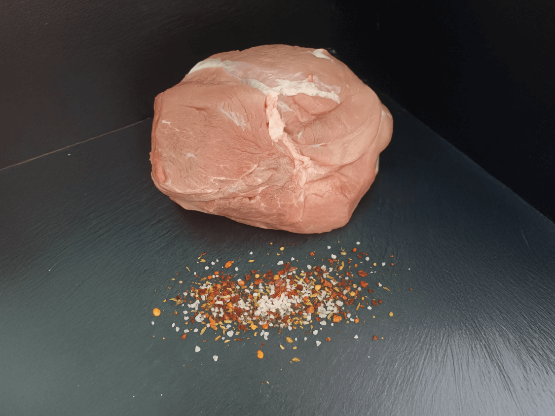 Schweinenuss auf Schieferhintergrund mit grobem Pfeffer