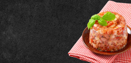 Sülze auf Teller mit einem Rot Weiß kariertem Handtuch auf Schieferhintergrund