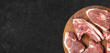 Kotelett auf einem Holzbrett auf Schieferhintergrund