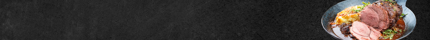 Braten mit Sauce und Kartoffelgratin angerichtet im Teller auf schwarzem Hintergrund