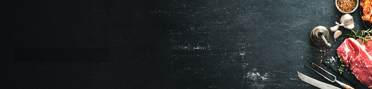 Banner Schieferhintergrund mit Auszug von Fleischstück Kräutern Gewürzen und Besteck