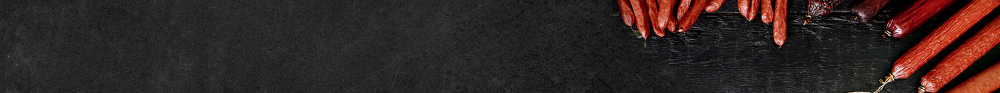 Verschiedene Salami Würstchen angerichtet auf schwarzem Hintergrund