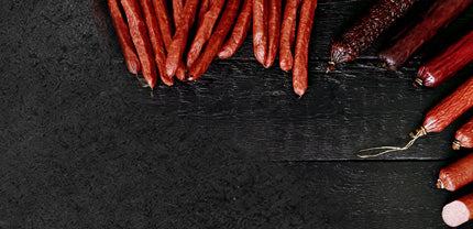 Verschiedene Würstchen angerichtet auf schwarzem Hintergrund