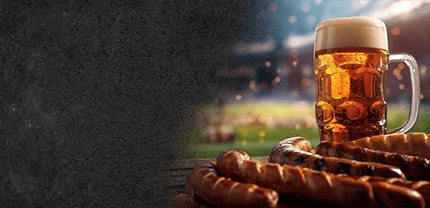 Ein Glas Bier mit Bratwürstchen im Fußballstation