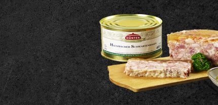 Hausmacher Schwartenmagen aus der Dose dekoriert auf Holzbrett mit Petersilie im Hintergrund die geschlossene Dose mit Etikett