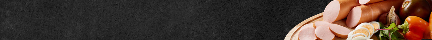 Angeschnittene Fleischwurst im Ring angerichtet auf Holzbrett dekoriert mit Ei Zwiebeln und Paprika auf schwarzem Hintergrund