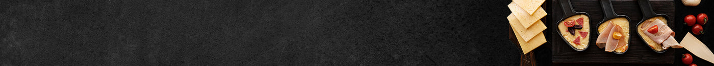 3 verschiedene Raclettepfannen gefüllt mit Tomaten Schinken Salami und Käse mit Meersalz und Pfeffer auf Schieferhintergrund