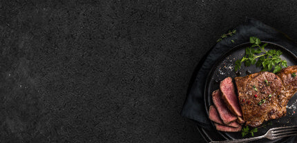 Rindersteak in Scheiben geschnitten auf Schieferhintergrund