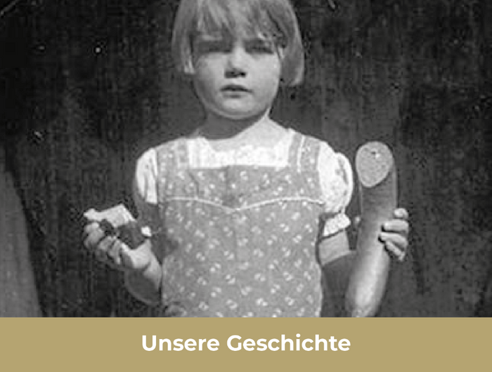 Unsere Geschichte mit kleinem Mädchen im Hintergrund mit einer halben Fleischwurst in der linken Hand