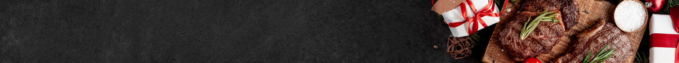 Rindersteaks gebraten mit Tomatendeko auf Holzbrett auf Schieferhintergrund Nahaufnahme