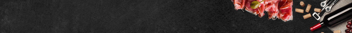 Roher Schinken mit Weinkorken einer Weinflasche und Flaschenöffner auf Schieferhintergrund