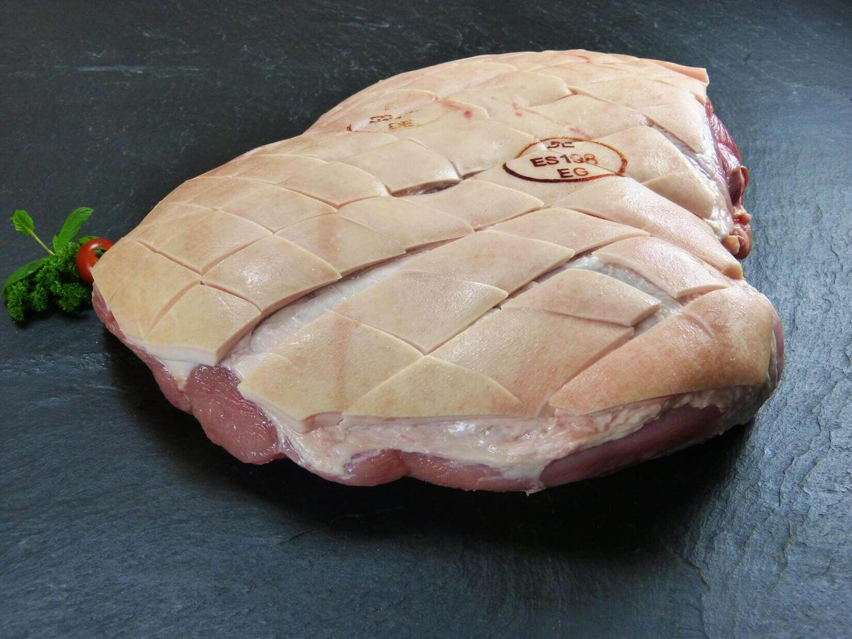 Schweineschinken mit Schwarte mit Petersilie und Tomate auf Schiefer Hintergrund