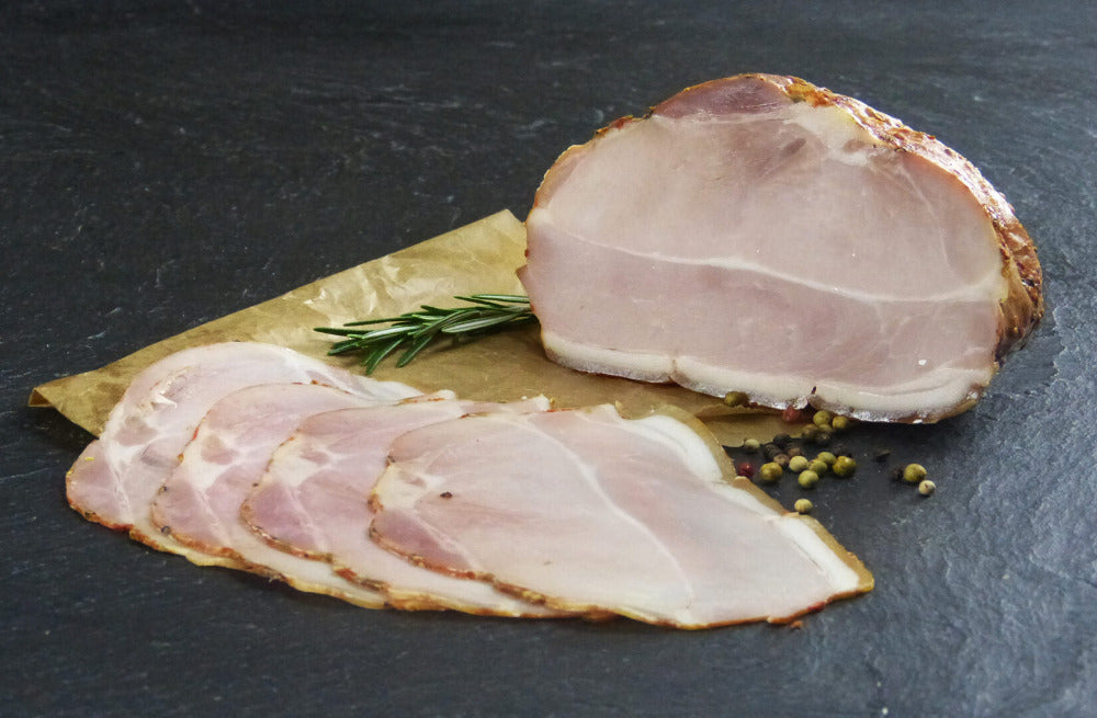 Schweine Krustenbraten Dekor zu Scheiben aufgeschnitten mit Pfefferkörnern und Thymian auf Schieferhintergrund