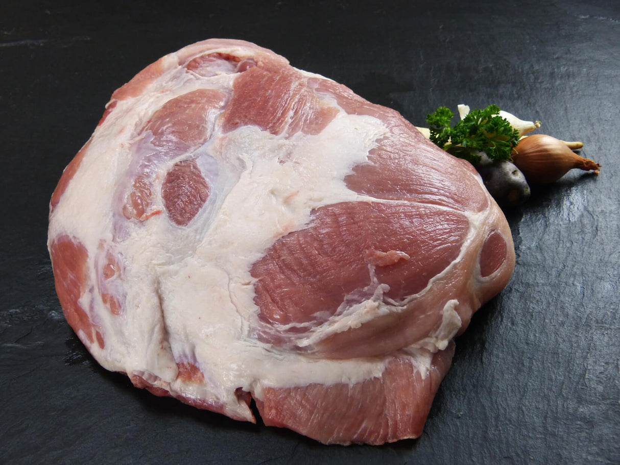 Schweine Schulter angerichtet mit Petersilie und Zwiebeln auf Schieferhintergrund