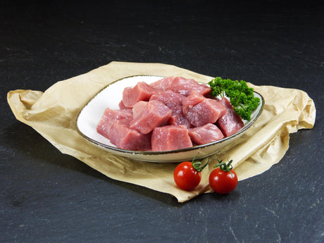Schweinegulasch mit Petersilie und Tomaten aus Schieferhintergrund