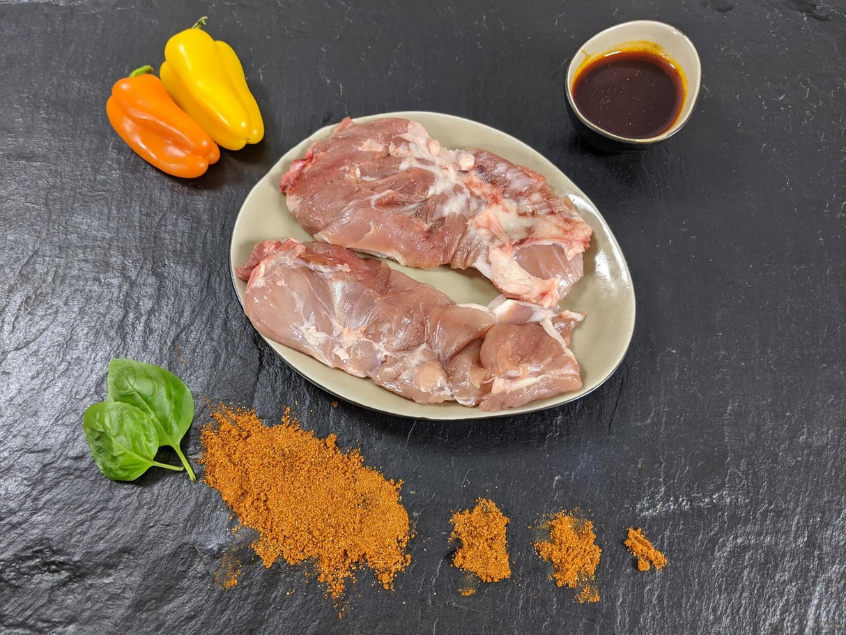 Spider Steak Kachelfleisch Paprika auf Teller mit einer Schale Marinade Paprikas Kräutern und Paprikapulver auf Schieferhintergrund