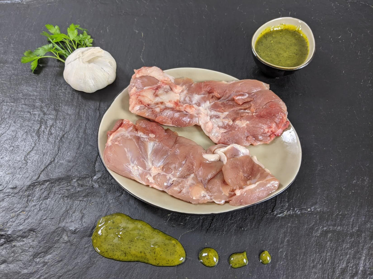 Spider Steak Kachelfleisch Kräuter Knoblauch auf Teller mit einer Schale Marinade Knoblauchknolle und Kräutern auf Schieferhintergrund