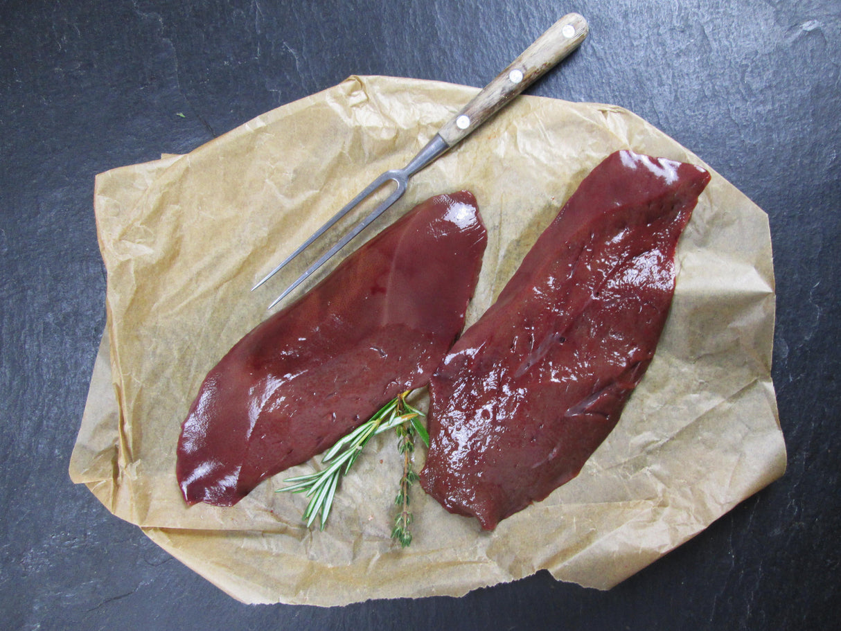 Schweine Leber in Scheiben mit Thymian und Rosmarin auf Schieferhintergrund