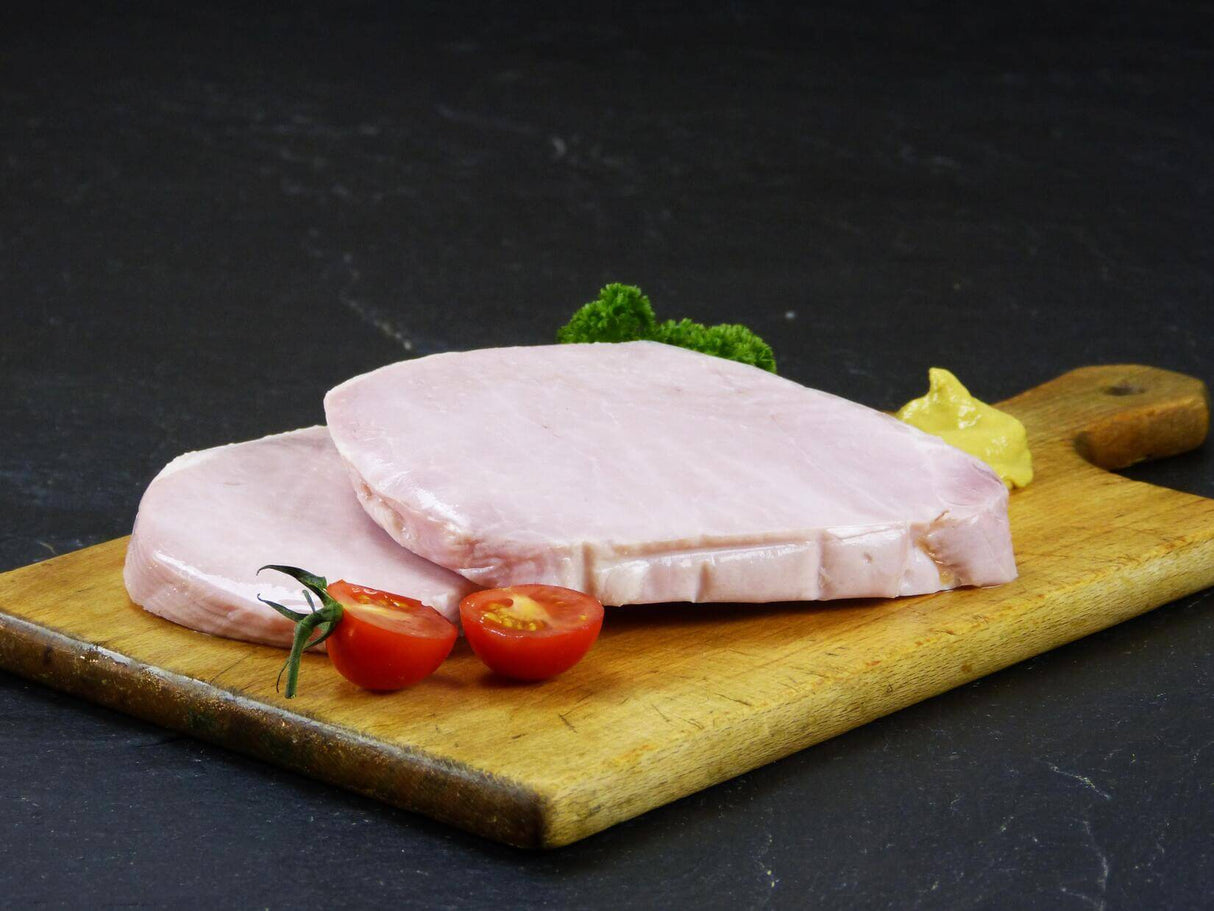 Gekochter Schweinelachs mit Tomate und Senf und Petersilie auf Schieferhintergrund