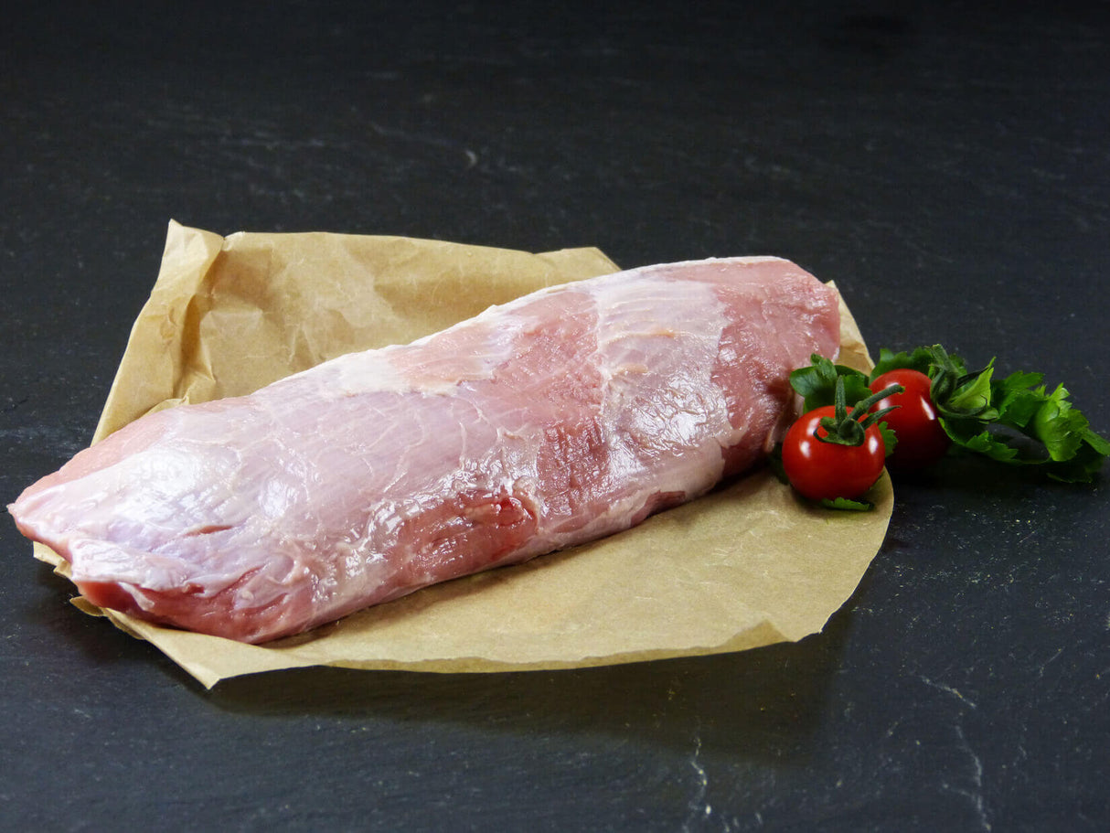 Kalb Semerrolle auf Backpapier angerichtet mit Tomaten und Kräutern auf Schieferhintergrund