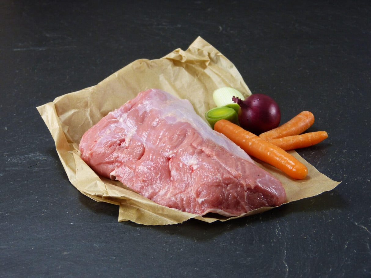 Kalb Tafelspitz auf Backpapier mit Suppengemüse auf Schieferhintergrund