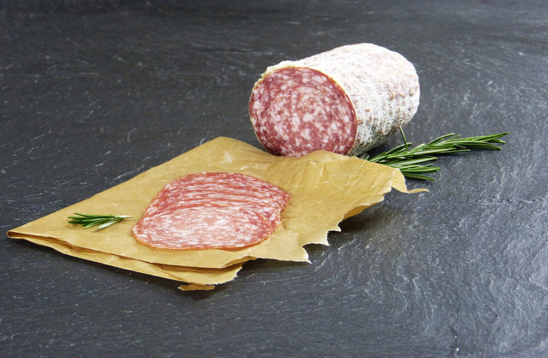 Mailänder Salami geschnitten mit Rosmarin auf Schieferhintergrund