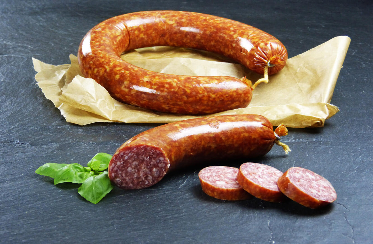 Mettwurst Braunschweiger Art mit Basilikum auf Schieferhintergrund