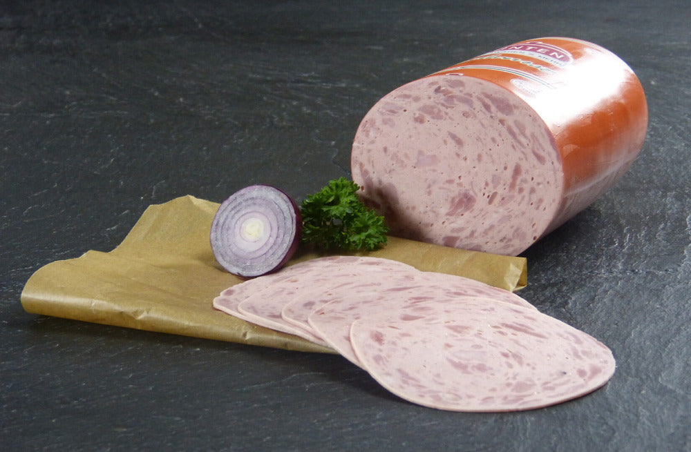 Jagdwurst als Aufschnitt mit roter Zwiebel und Petersilie auf Schieferhintergrund