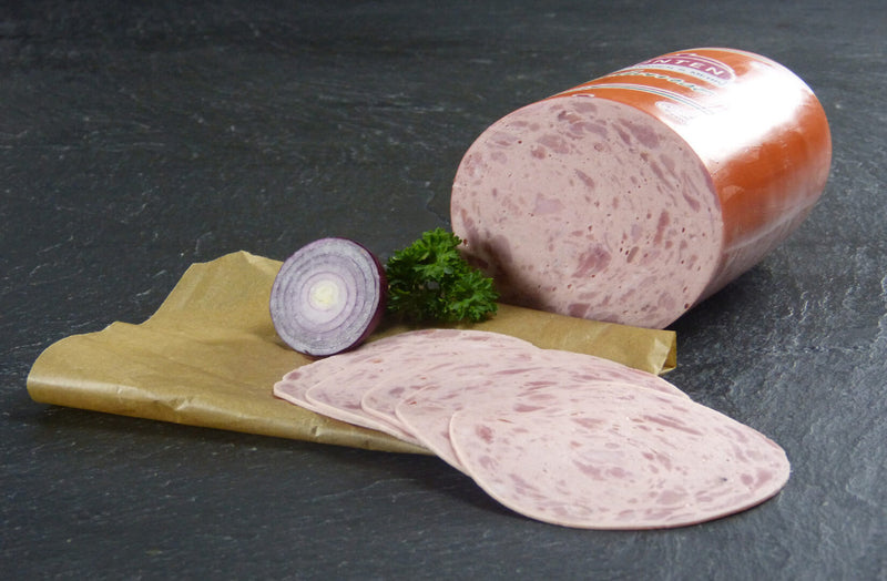 Jagdwurst als Aufschnitt mit roter Zwiebel und Petersilie auf Schieferhintergrund