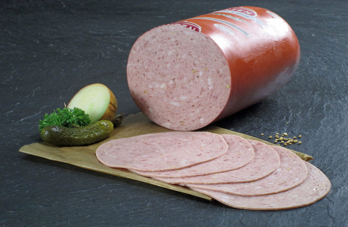 Bierwurst vom EIFEL Schwein geschnitten mit Essigurke Petersilie und Zwiebeln auf Schieferhintergrund