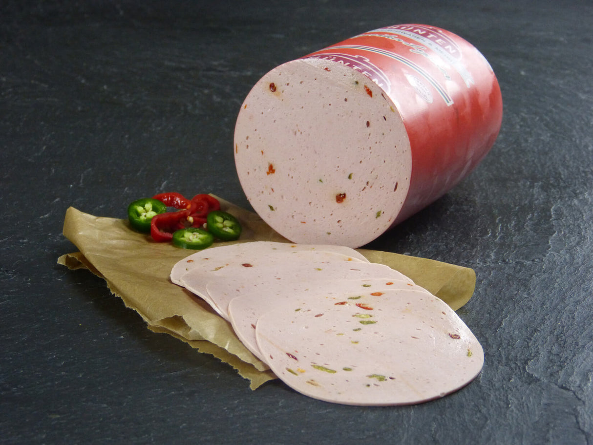 Paprikawurst Aufschnitt geschnitten mit Paprika und Peperonischeiben auf Schieferhintergrund