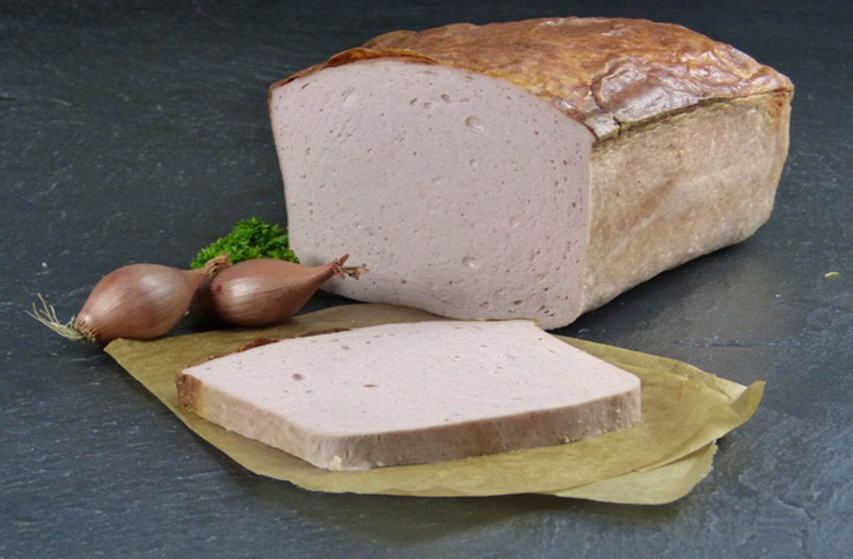 Fleischkäse gebacken Riegel mit Petersilie und Zwiebeln auf Schieferhintergrund