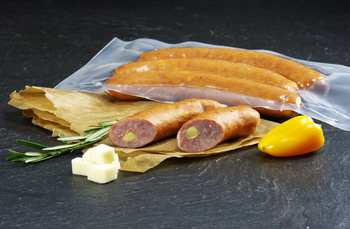 Käsebrater vom EIFEL Schwein mit Rosmarin Käsewürfeln und einer gelben Paprika auf Schieferhintergrund