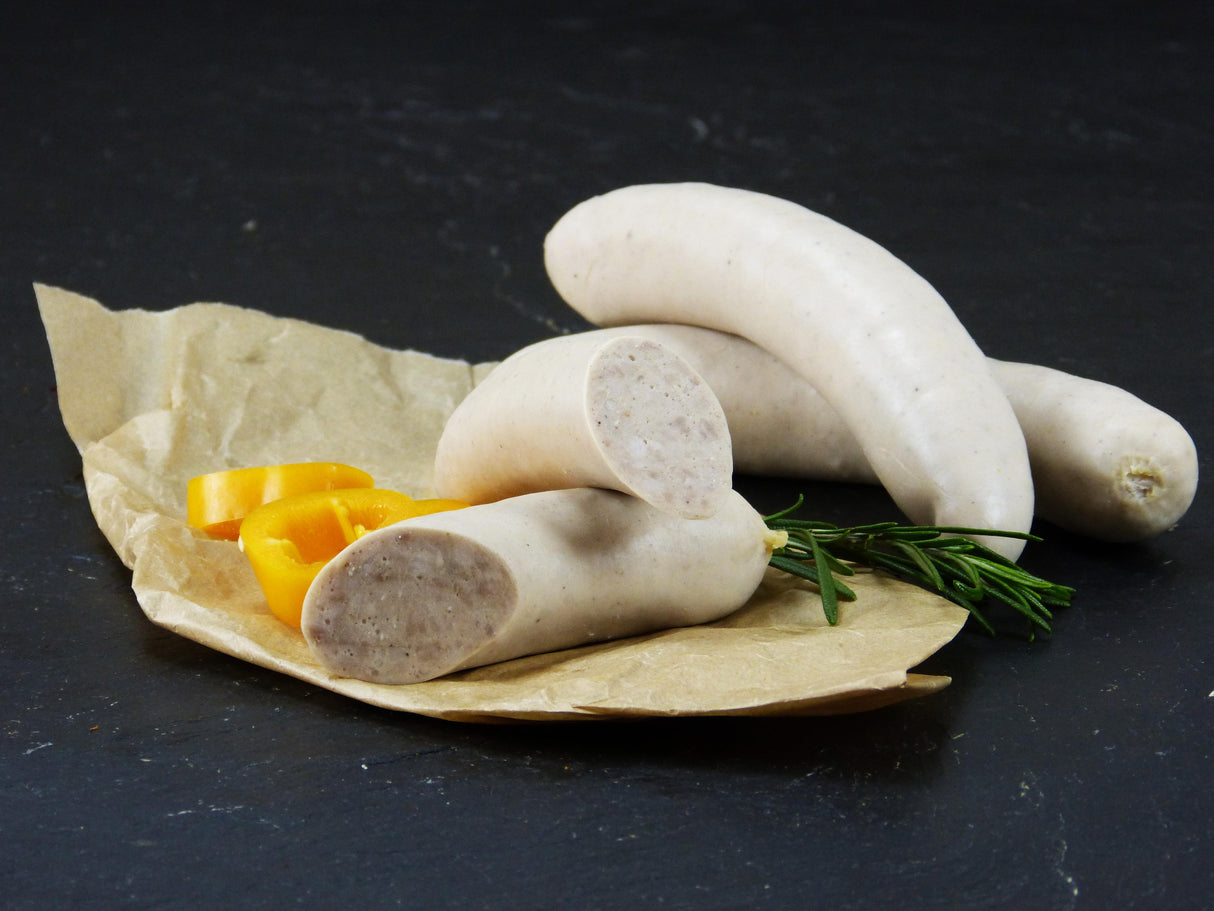 Rostbratwurst vom EIFEL Schwein mit gelber Paprika und Rosmarin auf Schieferhintergrund