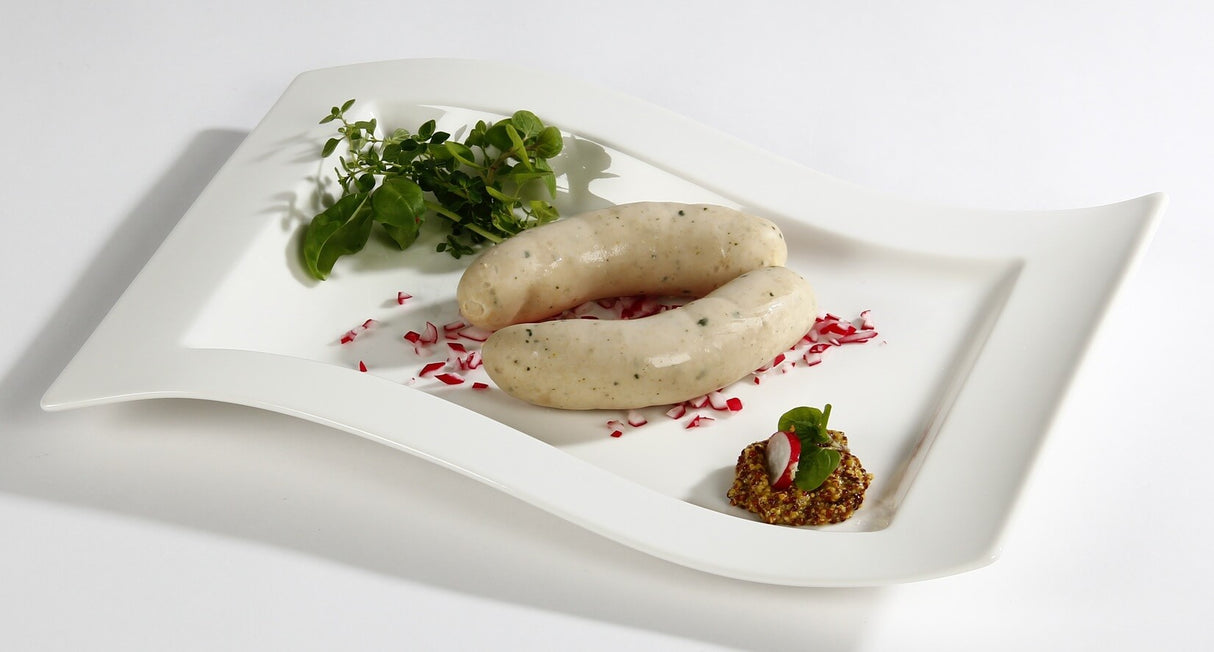 Weißwurst Münchner Art auf Teller angerichtet mit grobem Senf und Kräutern auf weißem Hintergrund