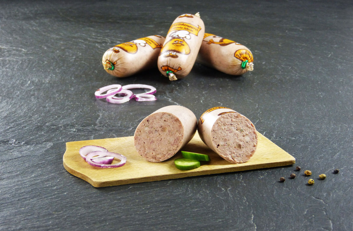Zwiebelleberwurst vom EIFEL Schwein mit Gurkenscheiben und Zwiebeln auf Schieferhintergrund