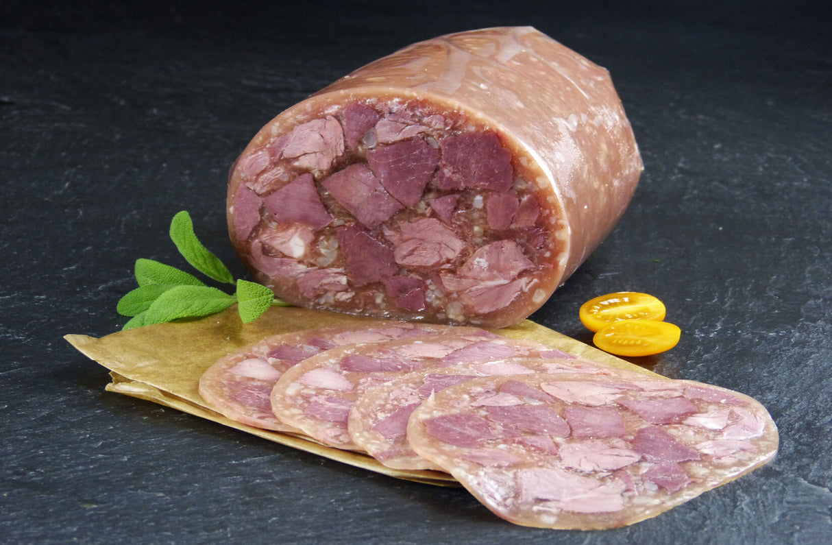 Schwartenmagen mit Rindfleisch geschnitten mit Minze und gelben Tomaten auf Schieferhintergrund